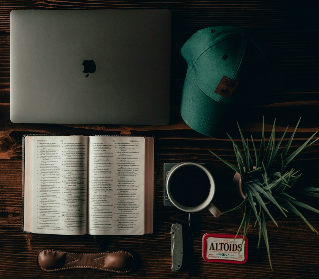 Overhead view of a calm workspace with notebook, coffee and plant